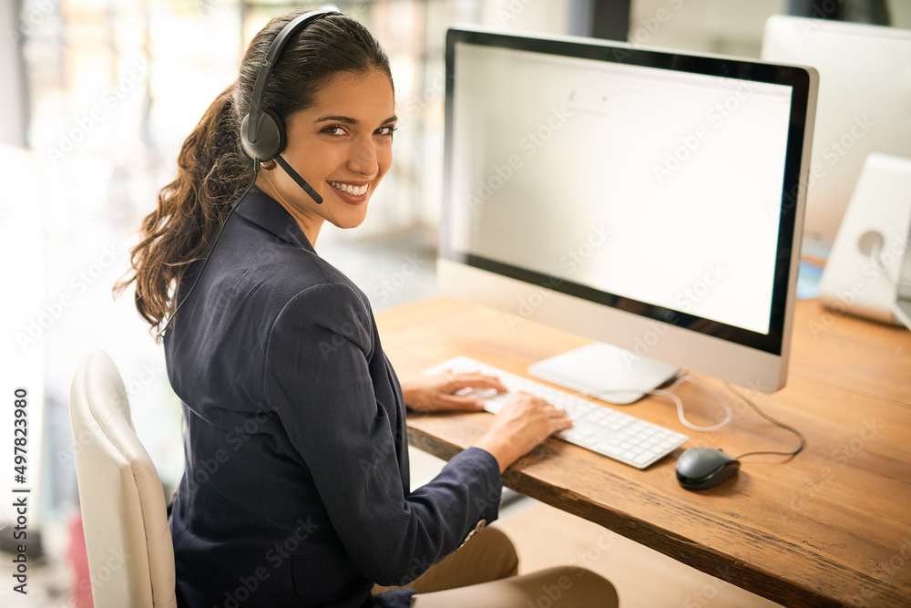Logging each and every call. High angle portrait of an attractive young woman working in a call center. Logging each and every call. High angle portrait of an attractive young woman working in a call center.