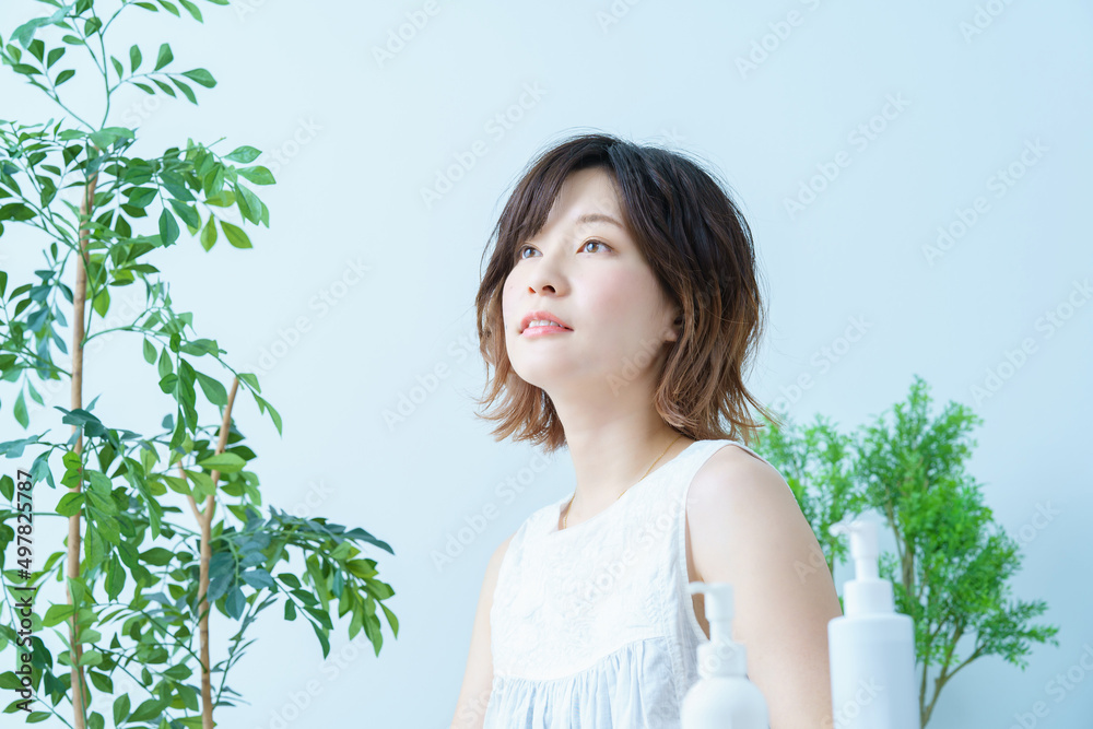 植物に囲まれてリラックスした表情の女性