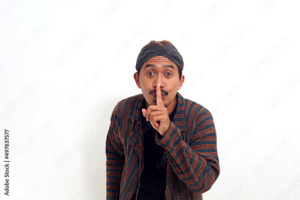 Asian man in java traditional costume brings his hand to his nose as a sign of Asian man in java traditional costume brings his hand to his nose as a sign of