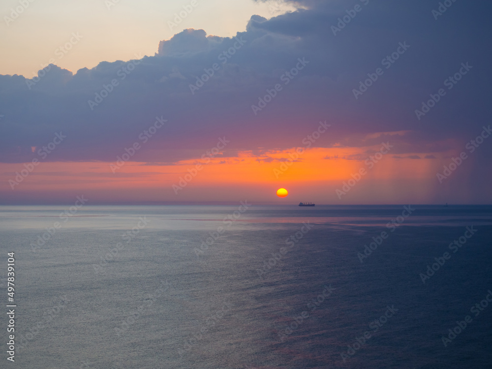 Thunderstorm at sea at dusk. The Beauty of Sunrise waves. Seascape with dramatic cloudy sky and rising sun in Oman. The view from beach Thunderstorm at sea at dusk. The Beauty of Sunrise waves. Seascape with dramatic cloudy sky and rising sun in Oman. The view from beach