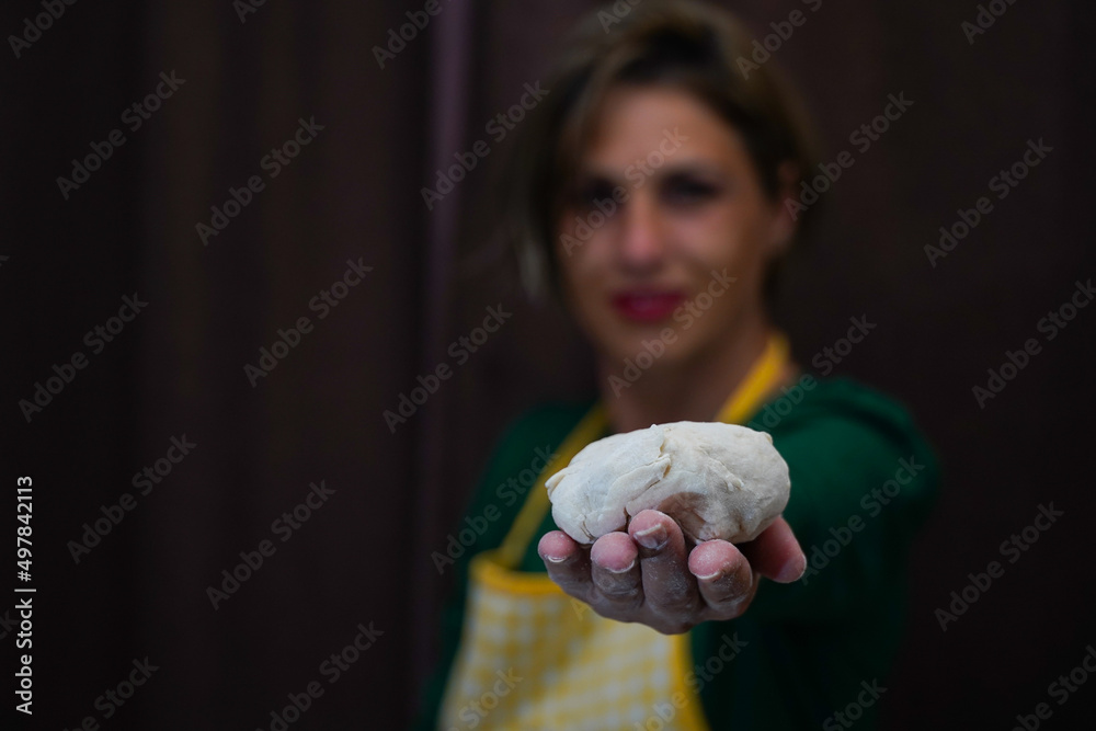 beautiful smiling woman presents the cake that will be transformed into bread. raw material for bread. beautiful smiling woman presents the cake that will be transformed into bread. raw material for bread.