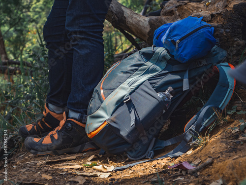 Camping adventure concept from Close up hiking backpack and trekking equipment in forest background.