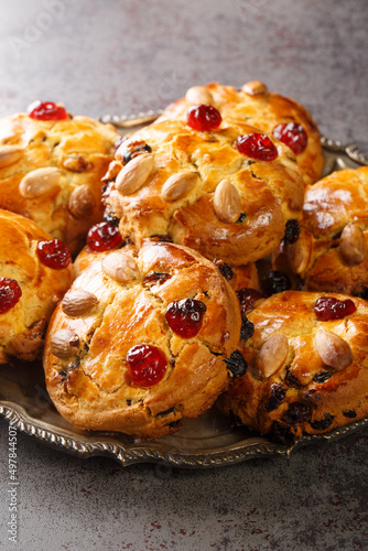 Yorkshire Fat Rascal topped with glace cherries and whole blanched almonds closeup in the plate. Vertical