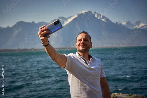 ugly man take a selfie at switzerland lake alps