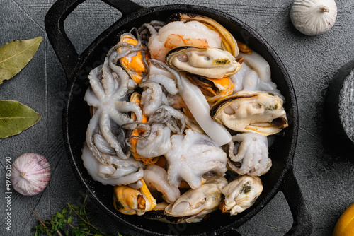 Fresh seafood arrangement mussels, squid octopus, on gray stone table background, top view flat lay