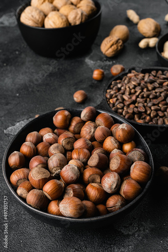 Organic Hazelnut whole nuts, on black dark stone table background