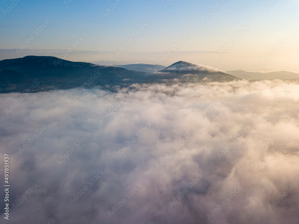 Flight over fog in Ukrainian Carpathians in summer. Mountains on the horizon. Aerial drone view. Flight over fog in Ukrainian Carpathians in summer. Mountains on the horizon. Aerial drone view.
