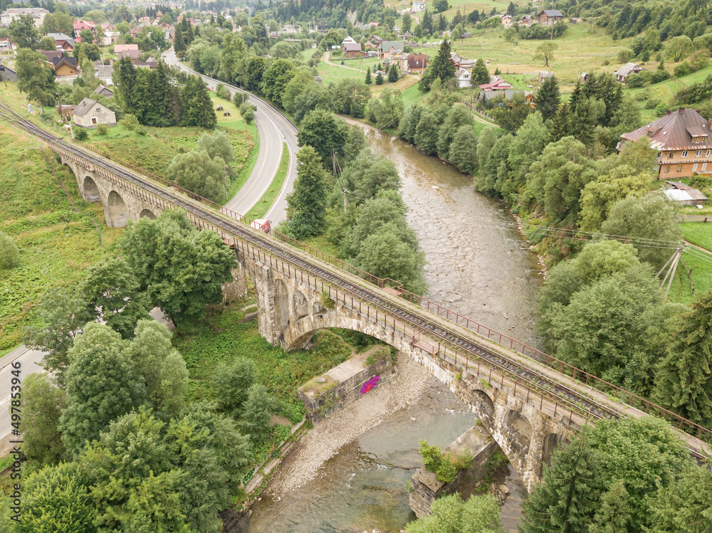 Fototapeta premium Old railway bridge in the mountains. Ukrainian Carpathians. Aerial drone view.
