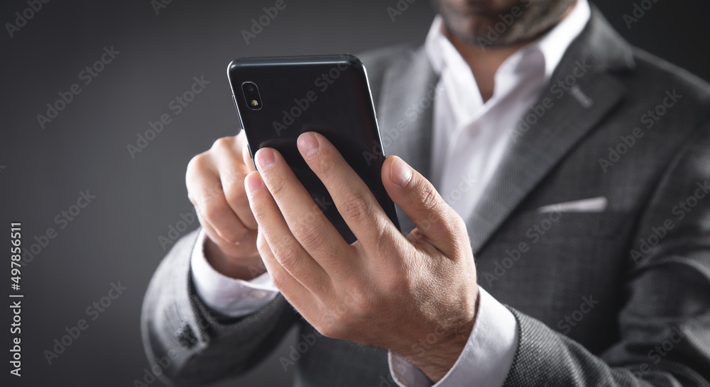 Caucasian businessman using smartphone in office. Caucasian businessman using smartphone in office.