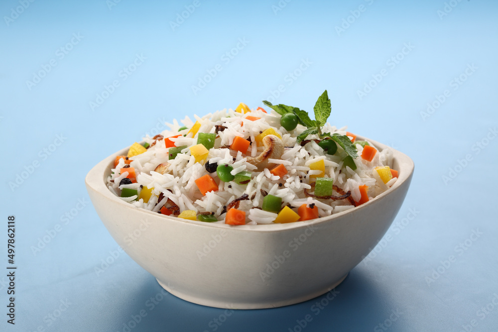 Indian veg biryani, veg pulav, Indian vegetable pulav, Biriyani, vegetable Biriyani served in a ceramic bowl on blue background Indian veg biryani, veg pulav, Indian vegetable pulav, Biriyani, vegetable Biriyani served in a ceramic bowl on blue background
