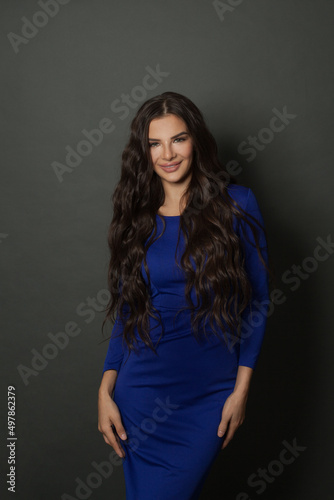 Beautiful woman fashion model brunette wearing blue dress in casual style on black.