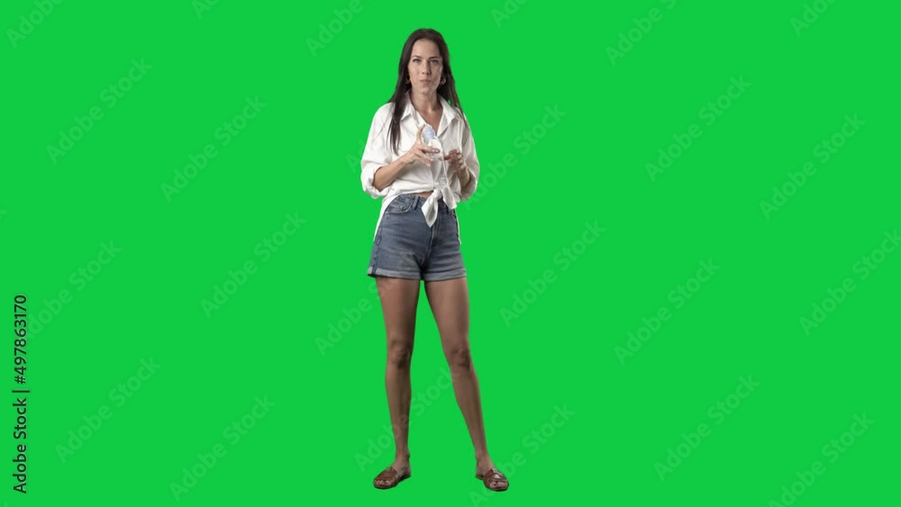 Standing young stylish woman drinking water from plastic bottle. Full body isolated on green screen background Standing young stylish woman drinking water from plastic bottle. Full body isolated on green screen background