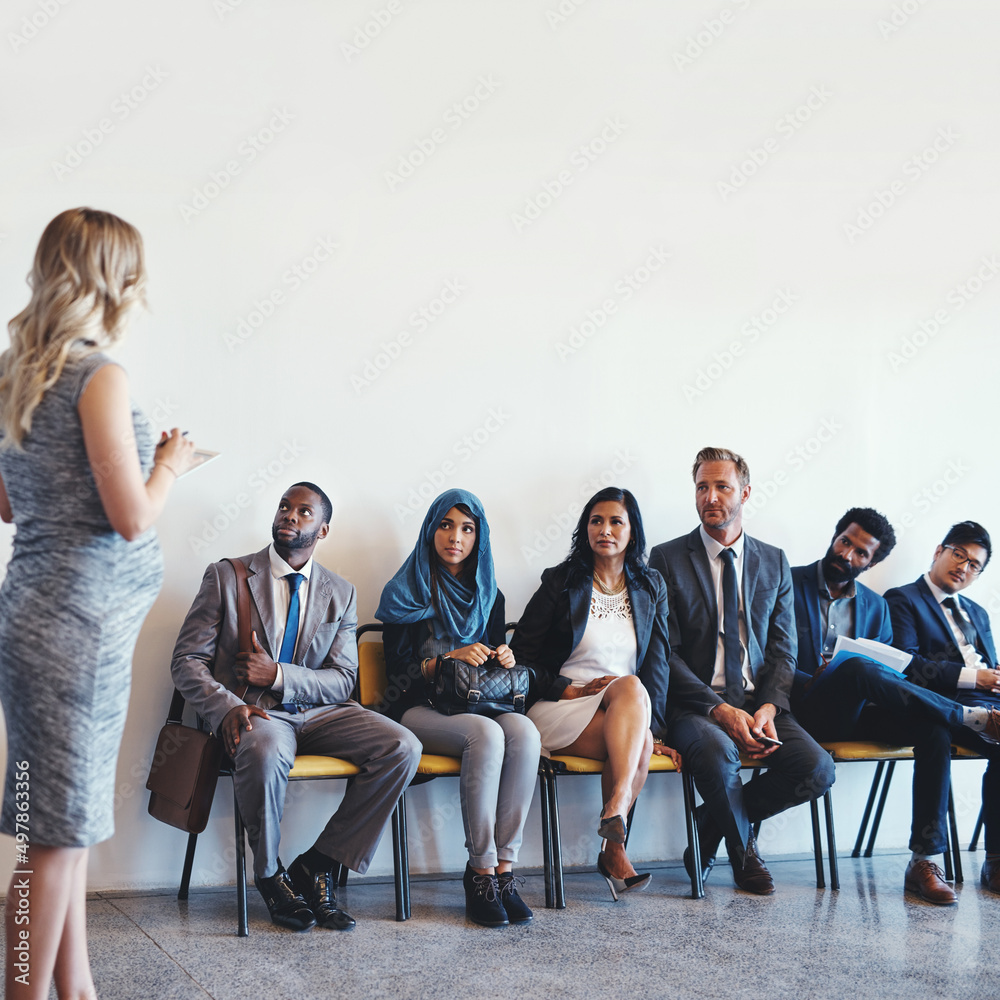 Obraz premium Thank you all for your patients. Shot of a group of confident businesspeople waiting in line for their interviews inside of a office during the day.