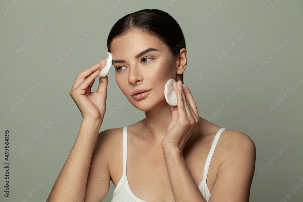 Brunette woman holding white cotton pads, portrait Brunette woman holding white cotton pads, portrait