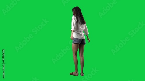 Young summer style woman spinning turning 360 around in slow motion. Full body isolated on green screen background