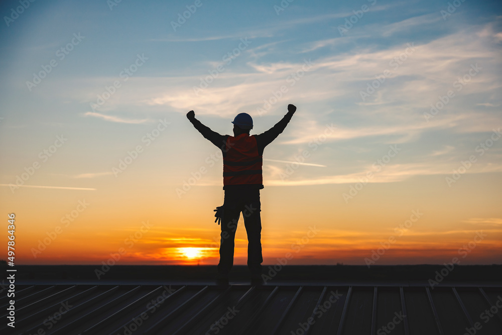 Fototapeta premium A construction worker lifting hands in the air and cheering for success.