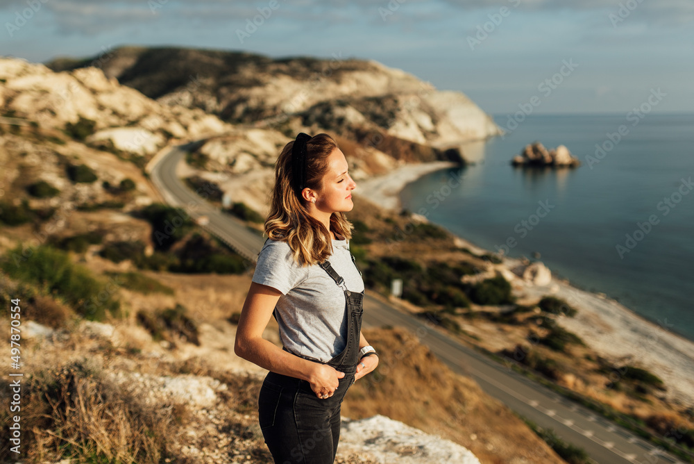 young woman 20-25 years of European appearance stands in the mountains on a background of sea and mountains young woman 20-25 years of European appearance stands in the mountains on a background of sea and mountains