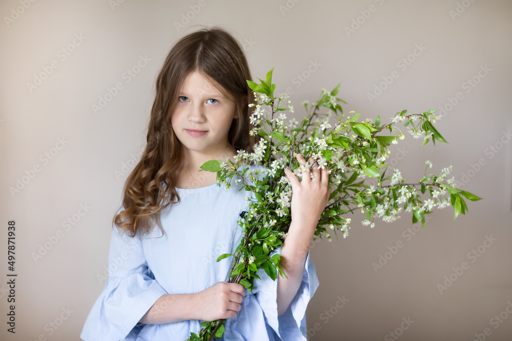 Charming european teenage girl with cherry blossom branch. Spring children's portrait. Gentle portrait of a preteen child Charming european teenage girl with cherry blossom branch. Spring children's portrait. Gentle portrait of a preteen child
