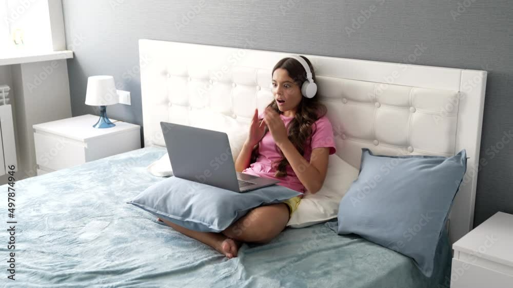 happy child in headphones laptop in bed having amazed face after shocking news, education happy child in headphones laptop in bed having amazed face after shocking news, education
