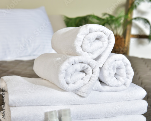 Freshly laundered fluffy towels on bed in hotel