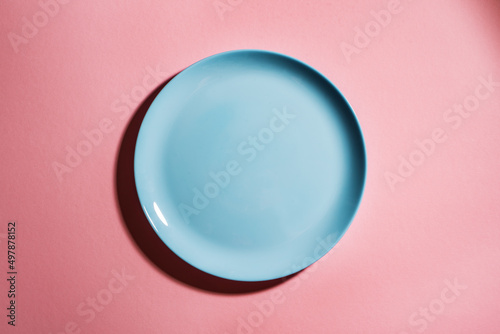 Blue empty plate on pink background