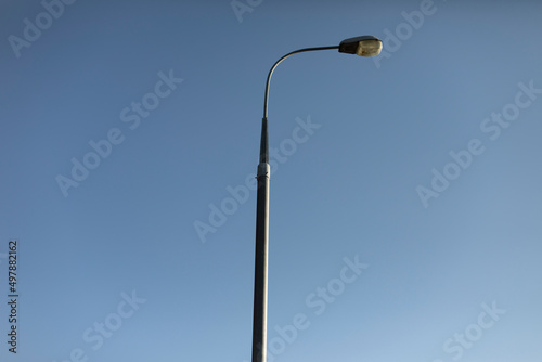 Pillar against sky. Lighting fixture in city. Pole with lamp.