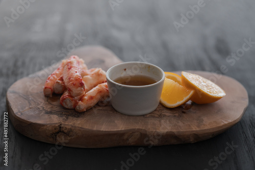 Crab served with sauce and sweet lemon on olive wood board photo