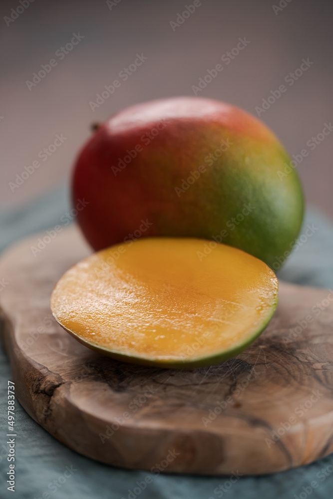 ripe fresh mango on olive wood board closeup