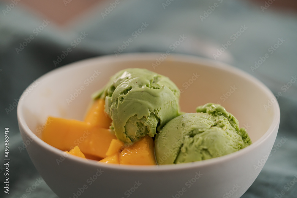 green matcha tea ice cream with fresh mango in white bowl green matcha tea ice cream with fresh mango in white bowl