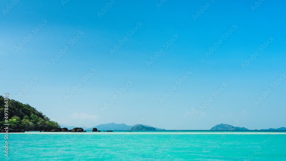 Scenic view of peaceful white sand bar and crystal clear turquoise water against clear blue sky. Koh Kham Island, Near Koh Mak Island, Trat Province, Thailand. Minimal panorama.