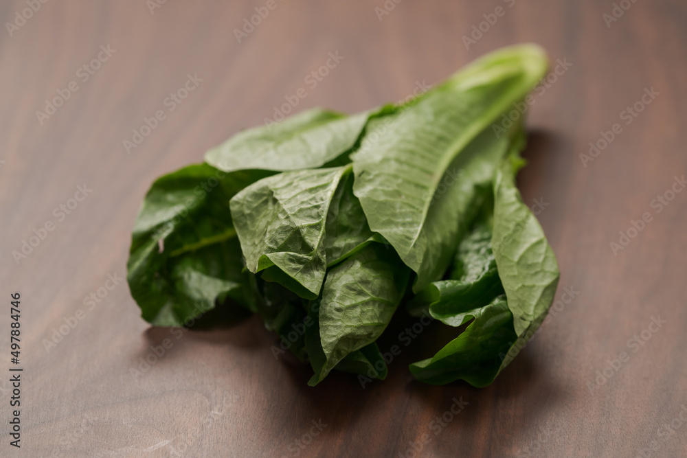 Small romaine lettuce leaves on walnut table Small romaine lettuce leaves on walnut table