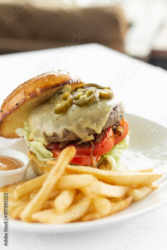 jalapeno cheese burger with french fries on restaurant table
