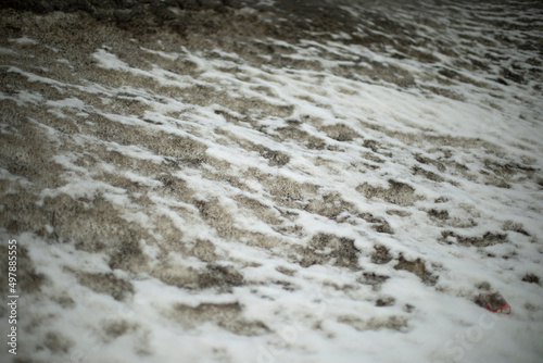 Dirty snow on side of road. Snow melts on asphalt. Situation on road after precipitation.