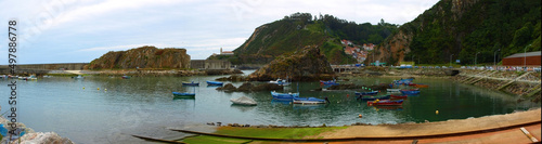 Small fishing port with rocks and boats in northern Spain. Copy space. Selective focus.