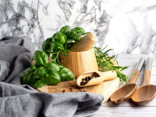 Photo Herbs and Spices, Mortar and Pestle, wooden board, rosemary and basil, grey apro