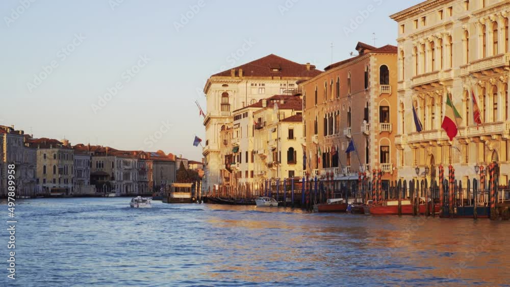 Venice Italy sailing during sunrise on the calm waters of Grand Canal with traditional low-rise buildings along the banks. Venice Italy sailing during sunrise on the calm waters of Grand Canal with traditional low-rise buildings along the banks.