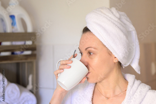 Woman in bath robe drinking coffee at spa.