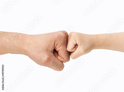 Shot of a little boy and his father sharing a fist bump with white background