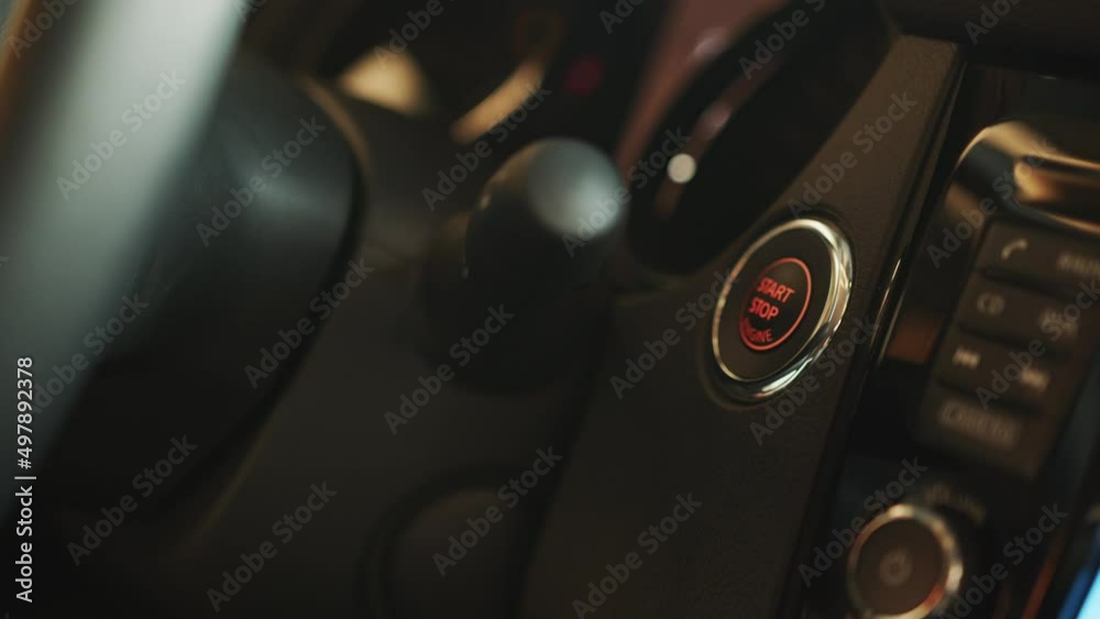 Starting car engine. Track in to the button. Finger press the button to start the car engine. Electronic means protection against car theft. Finger of hand presses ignition button car