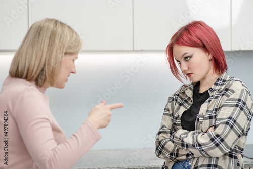Family conflict. Angry mother screams at scared daughter