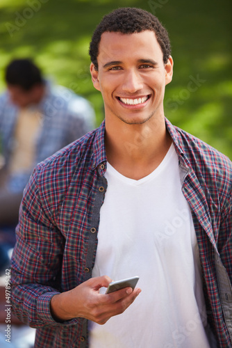 Connected to college life. Shot of a young man using his phone on campus.