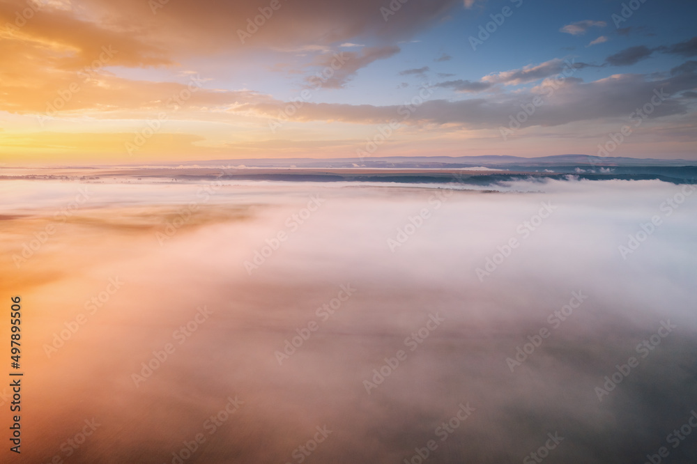 Picturesque scene of plain in the fog from a bird's eye view. Aerial photography, drone shot.