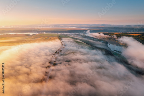 Picturesque scene of plain in the fog from a bird's eye view. Aerial photography, drone shot.