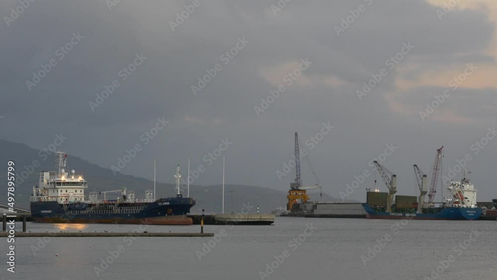 Cargo vessels using cranes to unload goods in Ponta Delgada, Azores Cargo vessels using cranes to unload goods in Ponta Delgada, Azores