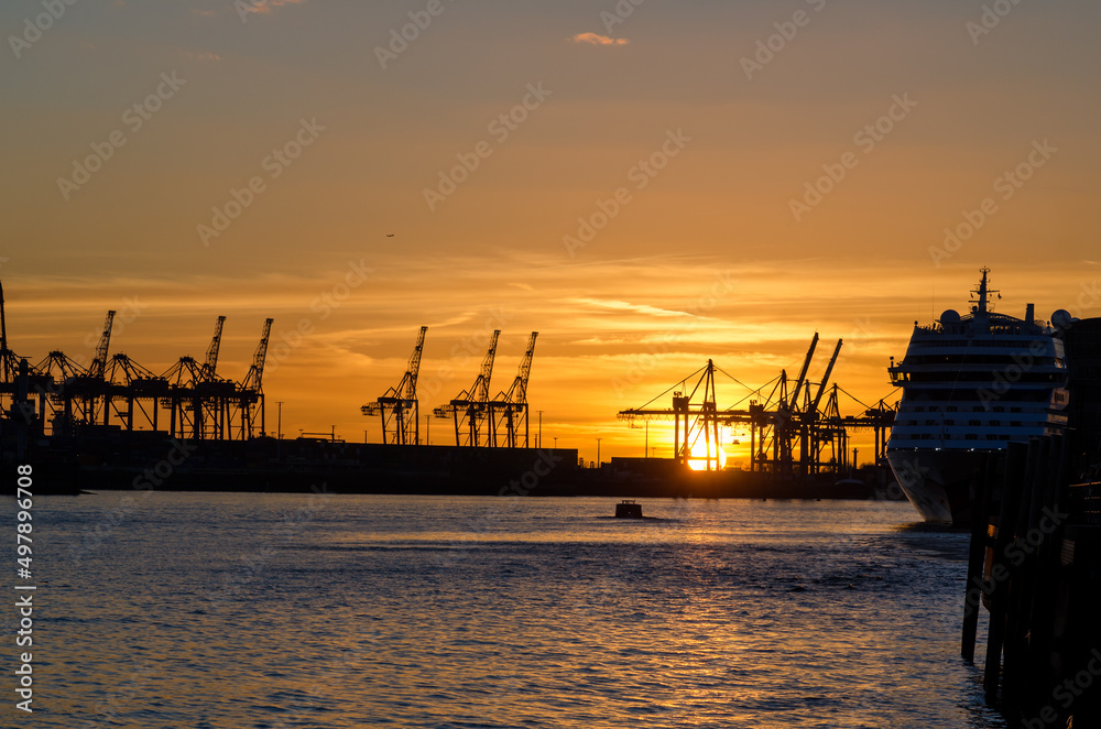 Hamburg harbor: cranes of a container terminal in the sunset