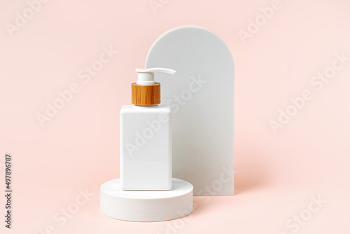 Pump bottle mockup on podium with  arch on  beige  background. Natural skincare beauty product.  Branding and packaging presentation.