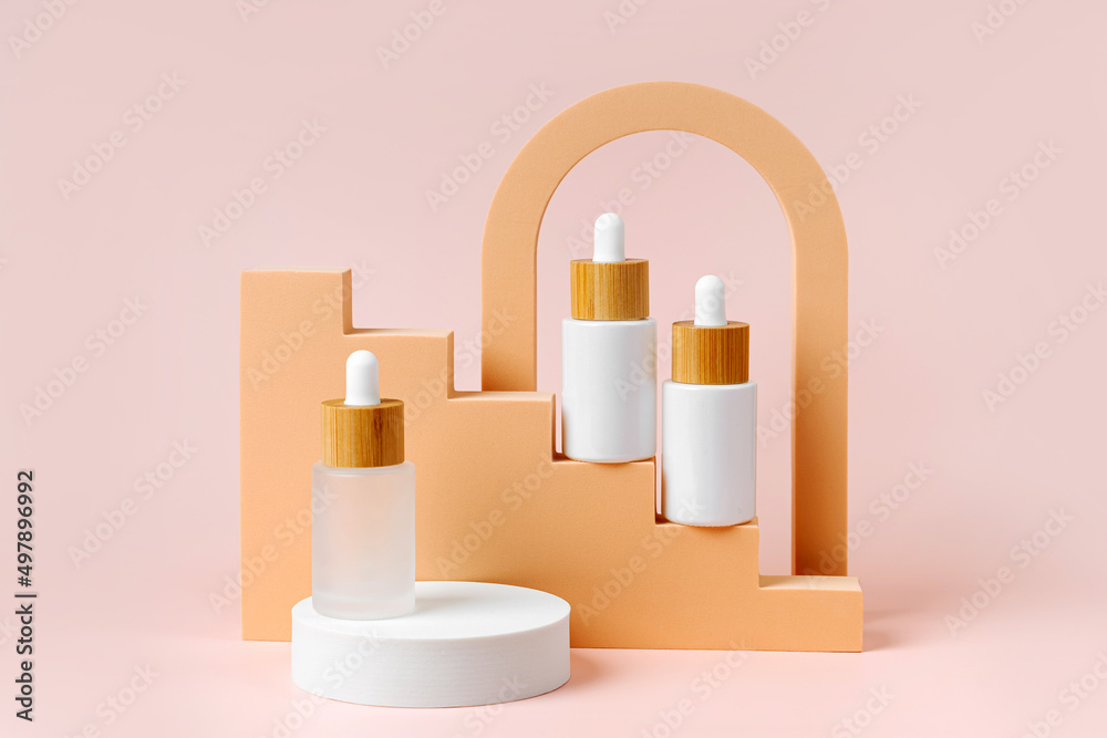 White dropper bottles mockup on beige stairs with geometric shapes and podium. Background for branding and packaging presentation. Natural skincare beauty product concept. White dropper bottles mockup on beige stairs with geometric shapes and podium. Background for branding and packaging presentation. Natural skincare beauty product concept.