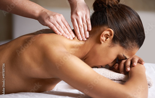 Releasing all the tension. Cropped shot of a young woman getting a neck massage at a spa.