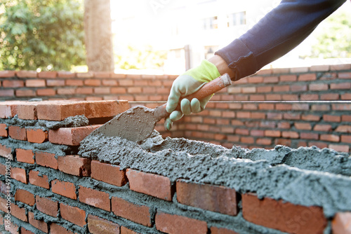 Fotografia, Obraz Close up of bricklayer building walls