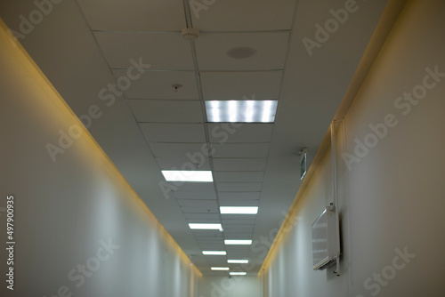 Lamps in hallway. Light on ceiling. Details of office building.